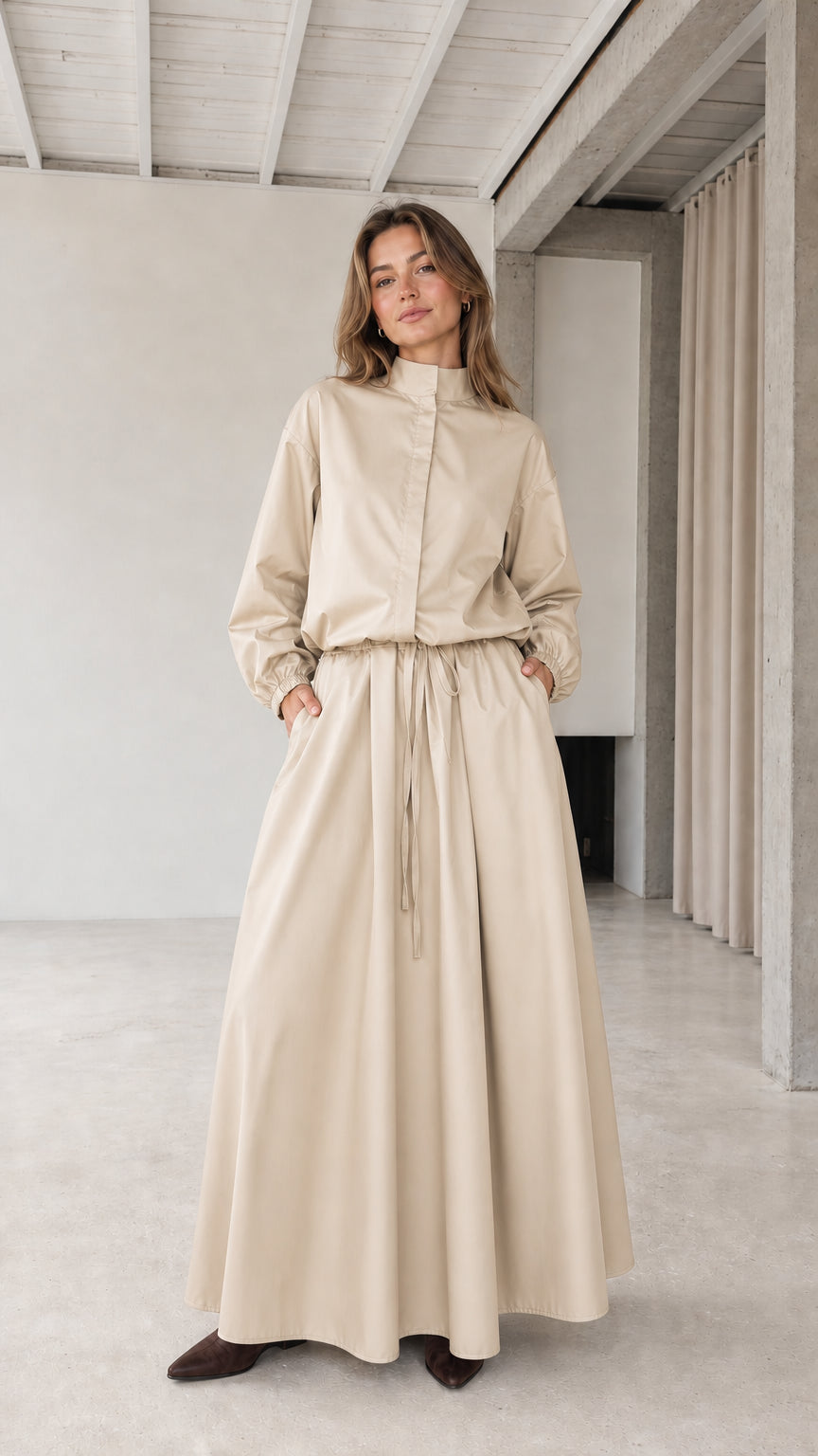 Front full view of woman wearing beige stand collar drawstring maxi dress