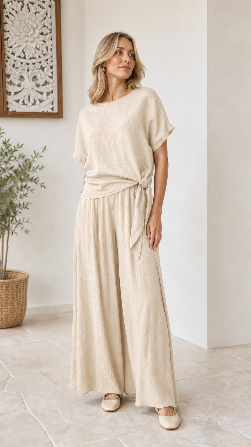 Model wearing neutral beige linen-feel matching top and wide-leg pant set