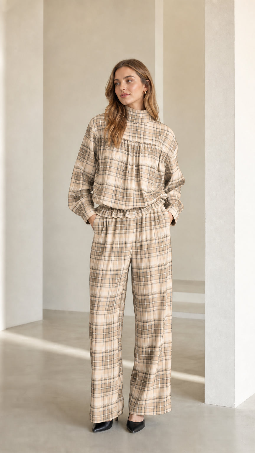 Model wearing warm beige plaid mock neck blouse and matching trousers set