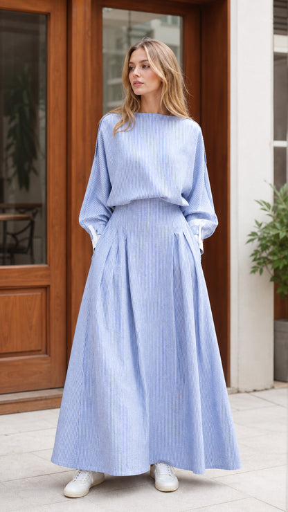 Front view of model wearing light blue striped boat neck maxi dress with white cuffs