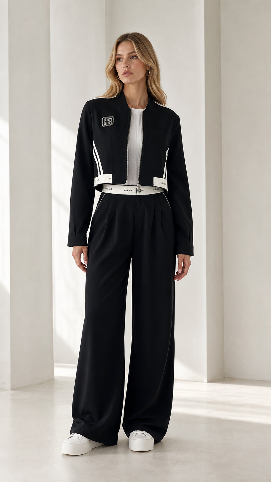 Full front view of model wearing black cropped bomber jacket and wide-leg trousers set