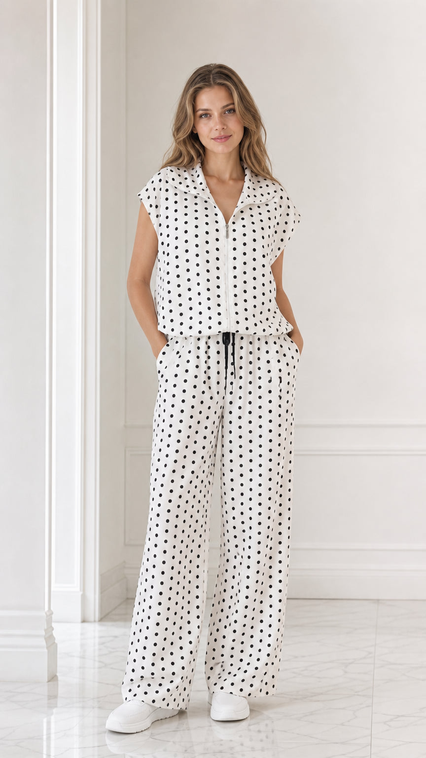 Full front view of model wearing white and black polka dot two-piece matching set with wide leg pants