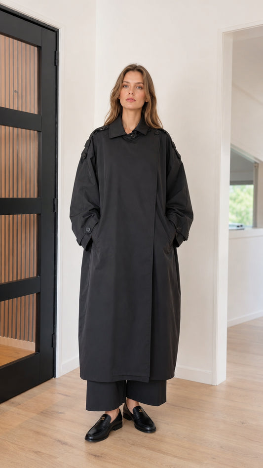 Front full view of woman wearing oversized black maxi trench coat
