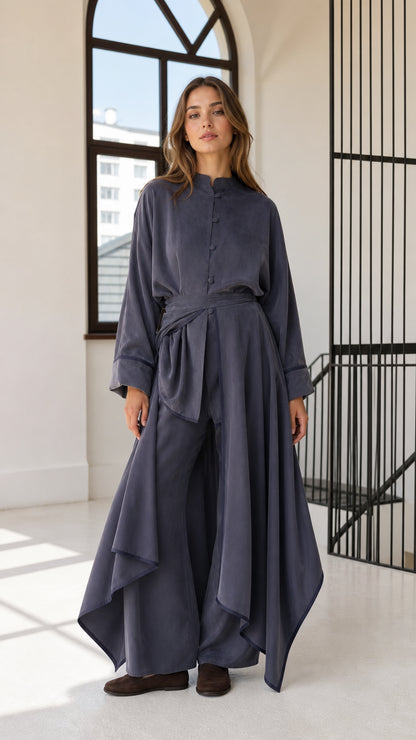 Front full view of woman wearing slate blue asymmetric draped tunic and matching wide-leg trousers set