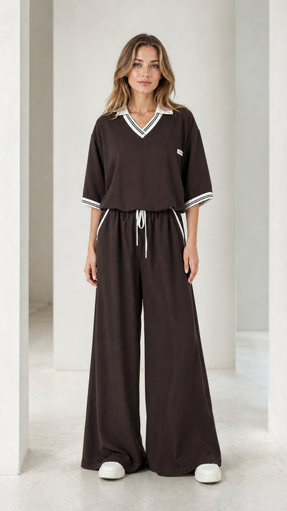 Front view of a chocolate brown women's wide-leg jumpsuit with striped collar and drawstring waist