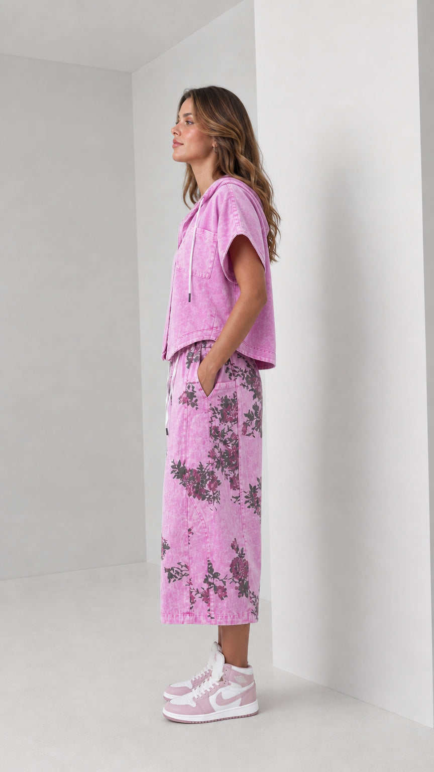 Side profile view of woman wearing washed pink hooded shirt and floral wide-leg pants set