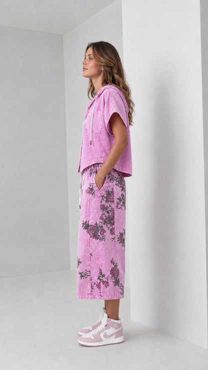 Side profile view of woman wearing washed pink hooded shirt and floral wide-leg pants set