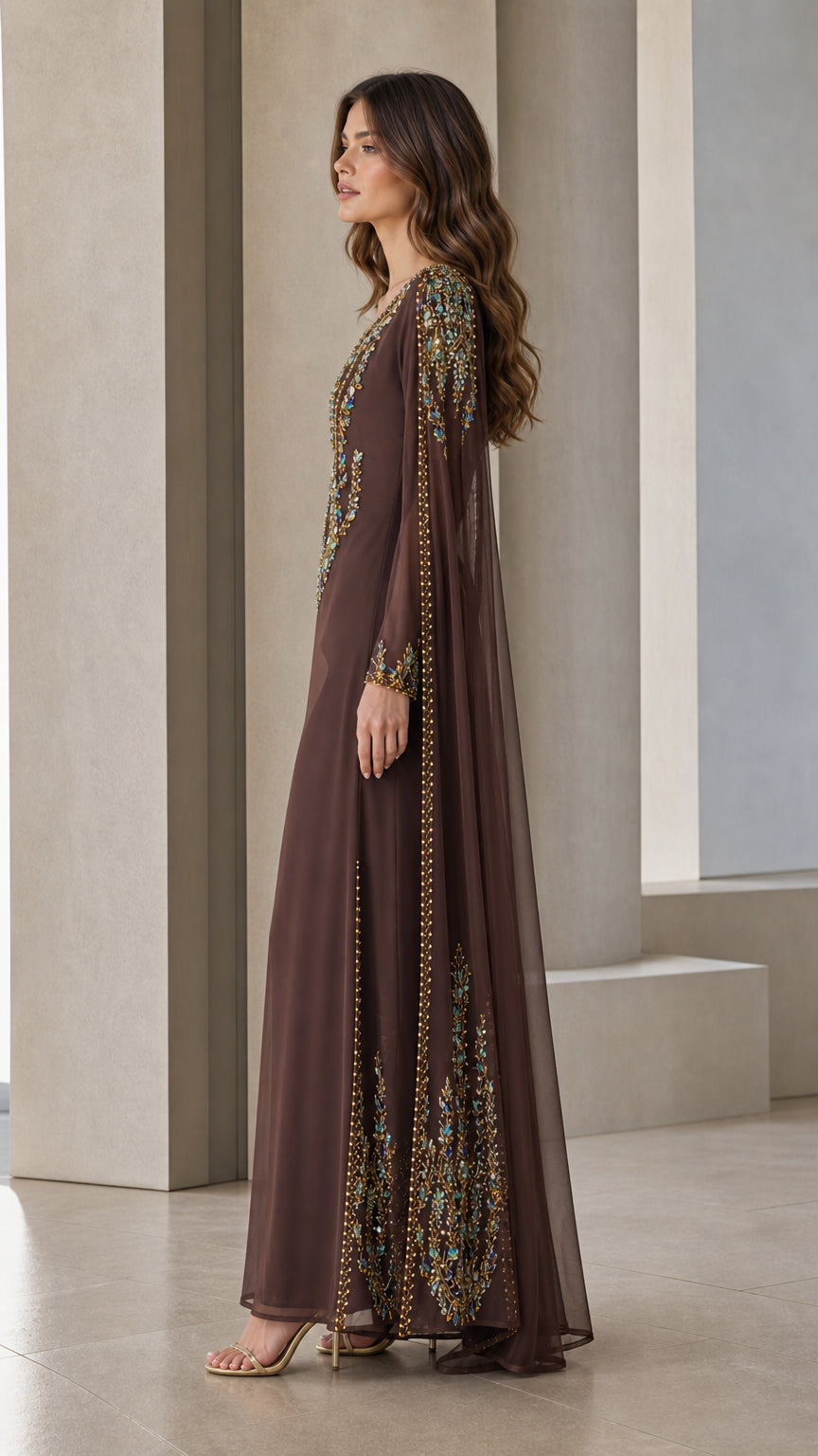 Side profile view of brown beaded cape evening gown showing draped sleeve design