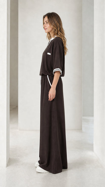 Side view of a chocolate brown wide-leg jumpsuit showing the relaxed fit and flowing leg