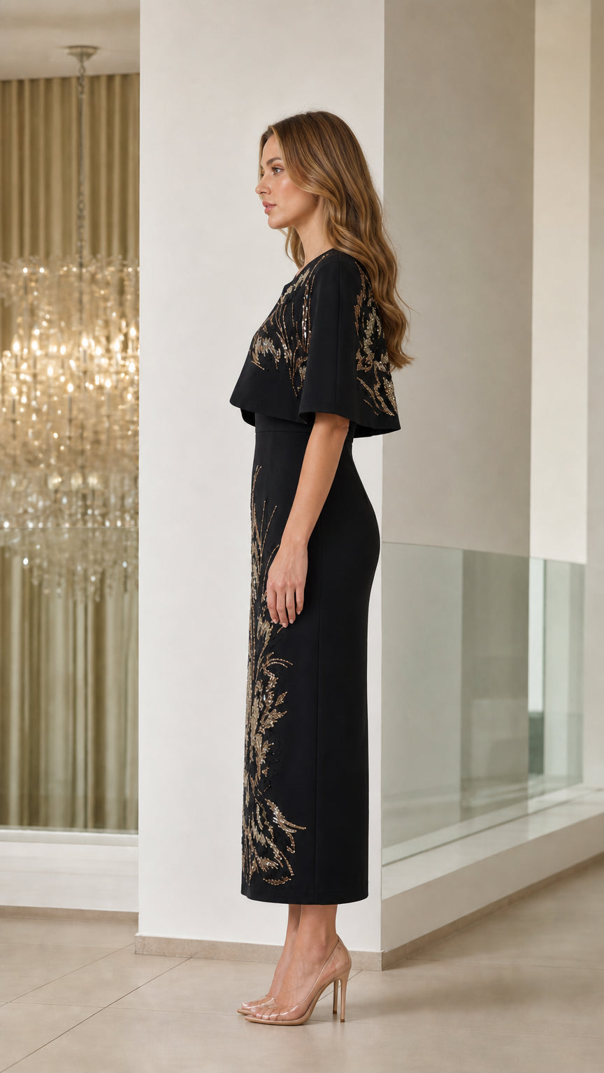 Side profile view of black embellished capelet sheath dress
