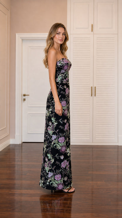 Side profile view of model wearing black sequin floral column maxi dress