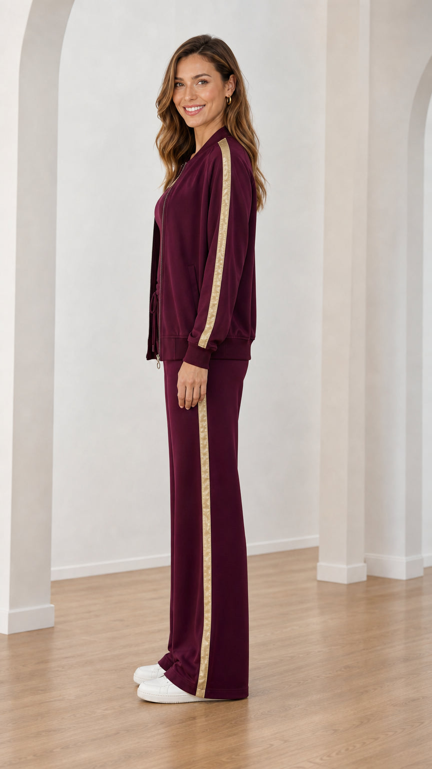 Side profile of burgundy wide-leg tracksuit set showing shimmer stripe on jacket and pants