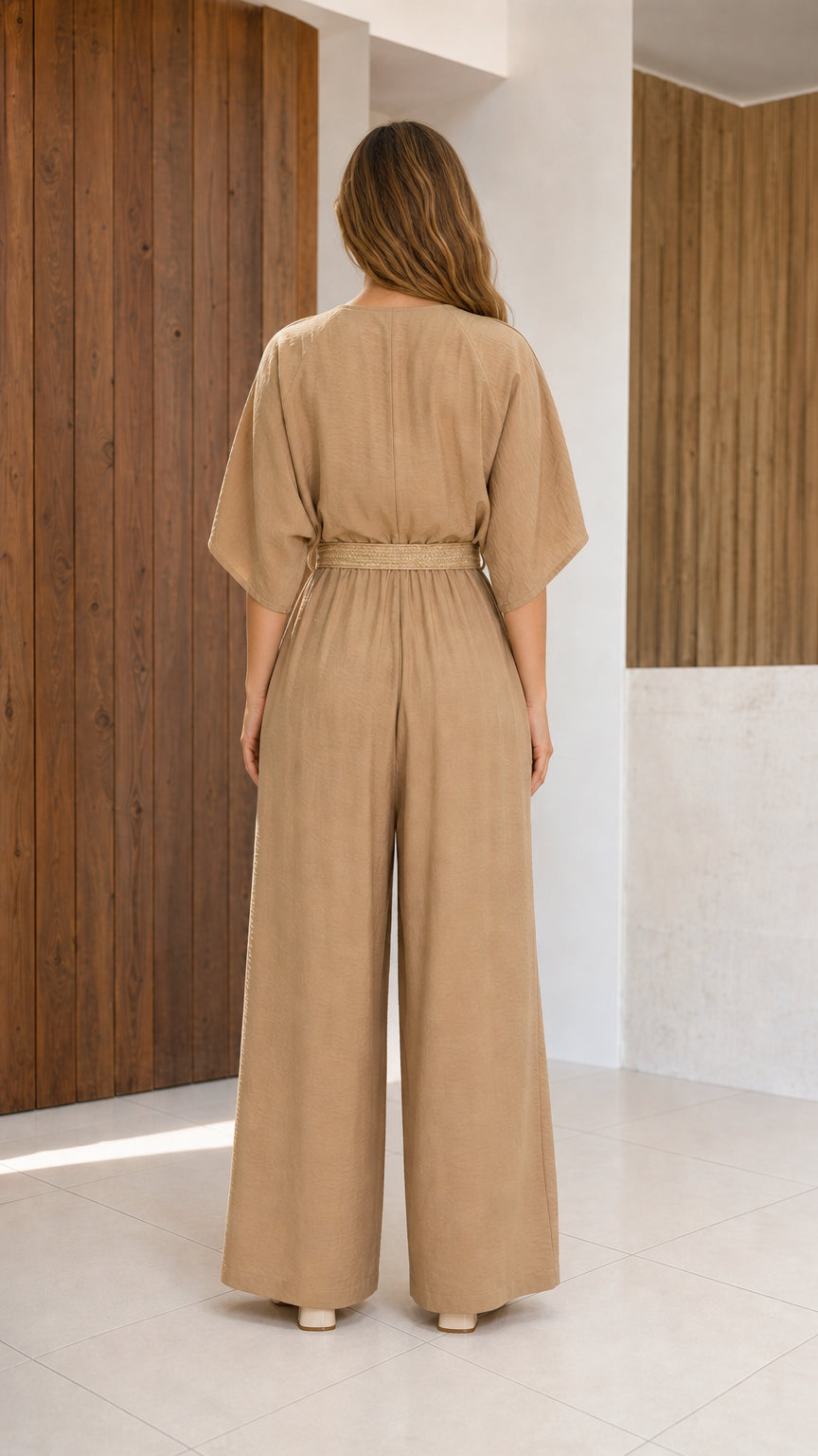 Back view of woman wearing beige relaxed-fit wide-leg jumpsuit