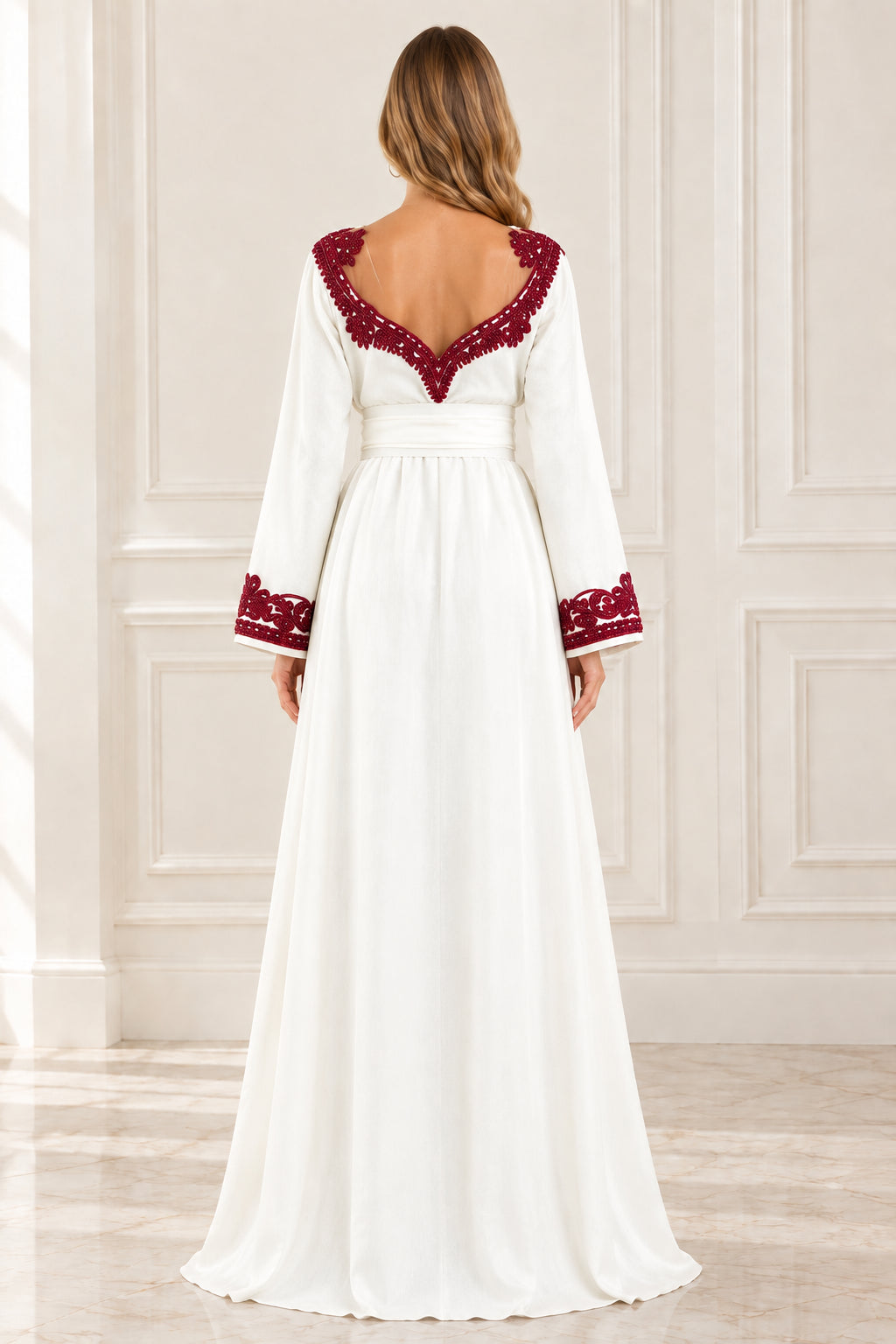 Back view of woman wearing white long sleeve kaftan dress with burgundy embroidered V-back neckline