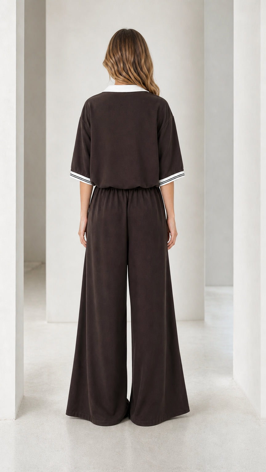 Back view of a chocolate brown women's jumpsuit with elastic waist and wide-leg silhouette