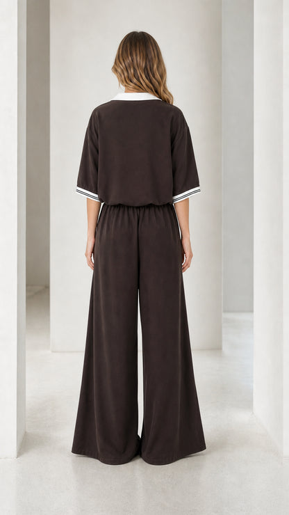 Back view of a chocolate brown women's jumpsuit with elastic waist and wide-leg silhouette