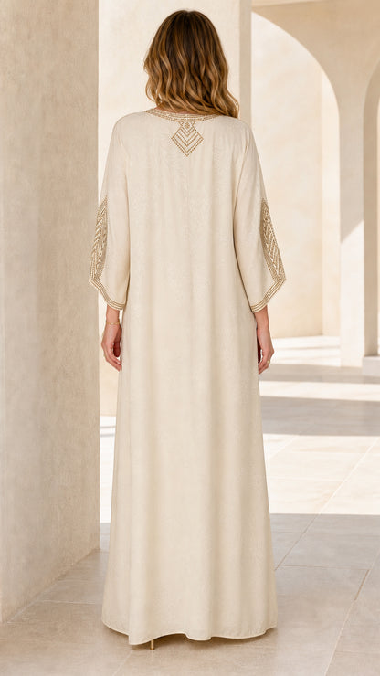 Back view of model wearing Cream kaftan dress with upper-back rhinestone embellishment