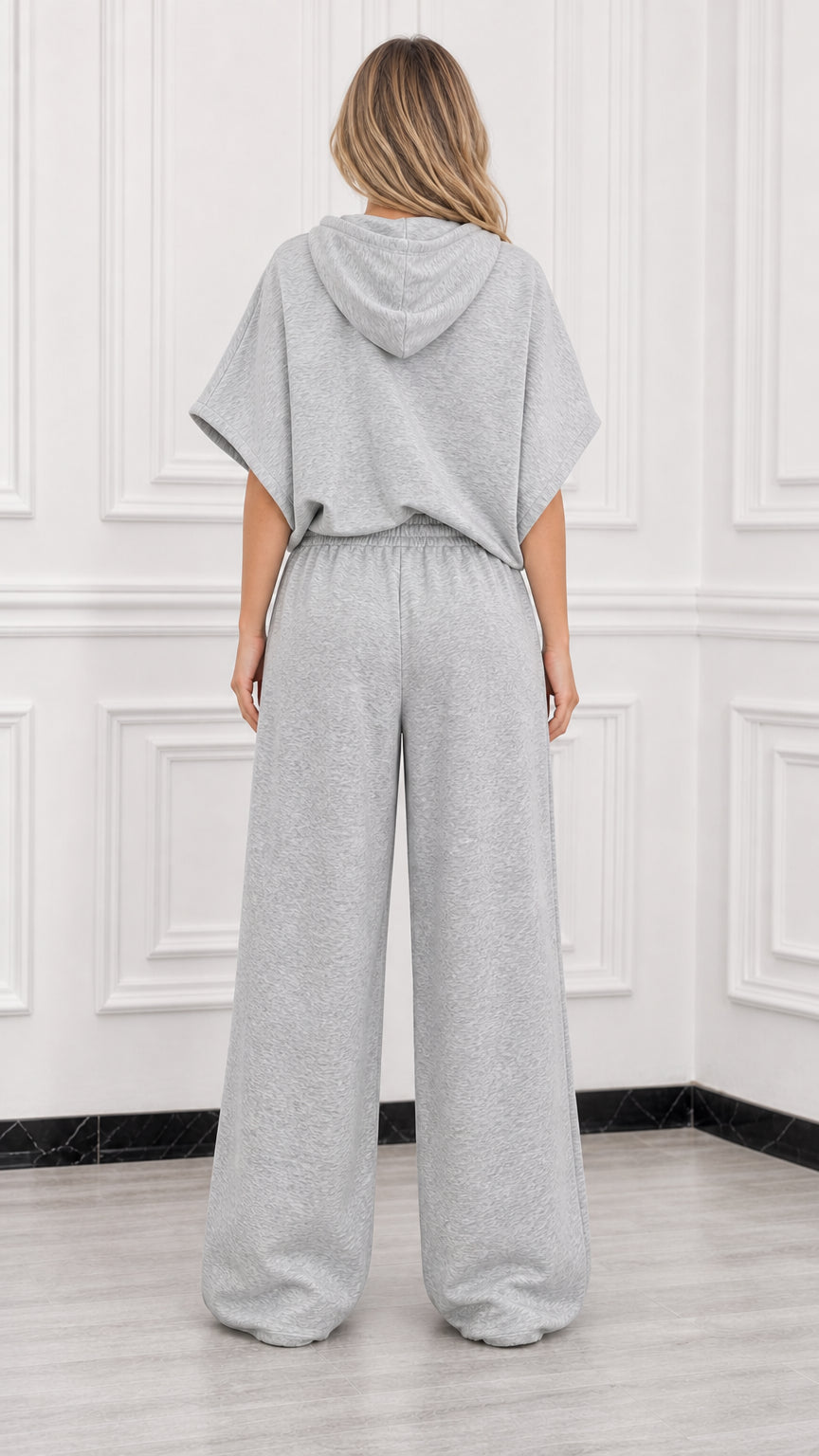 Back view of model wearing heather grey short sleeve hooded top and relaxed wide leg pants