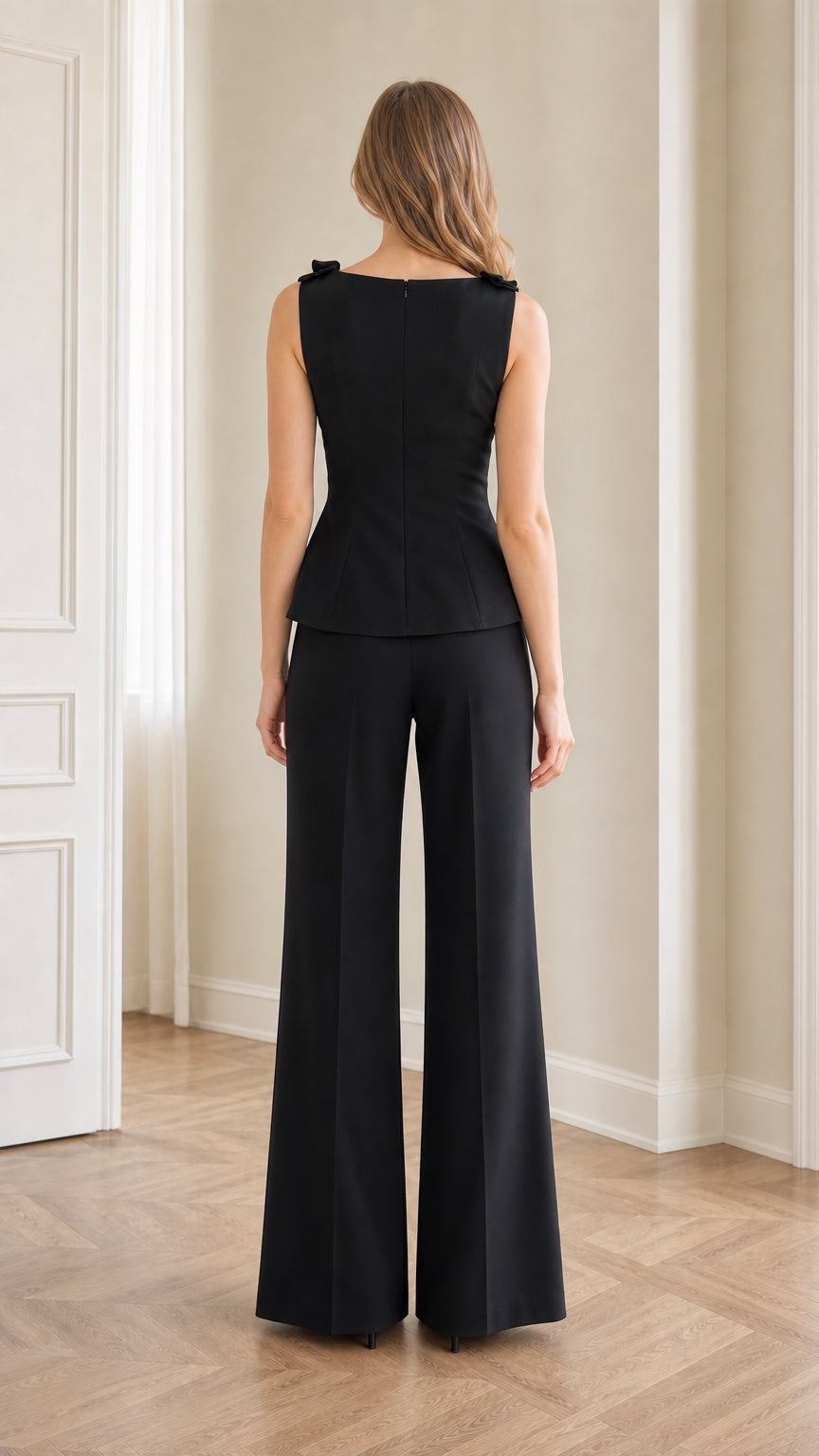 Back view of model wearing black tailored peplum top and wide-leg trousers set
