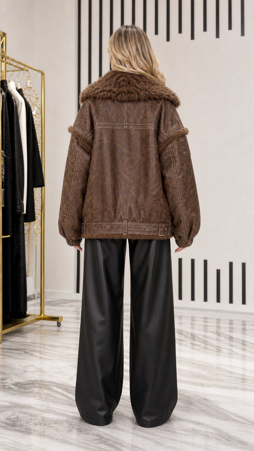 Back view of model showing dropped shoulder seams and belted hem on brown aviator jacket