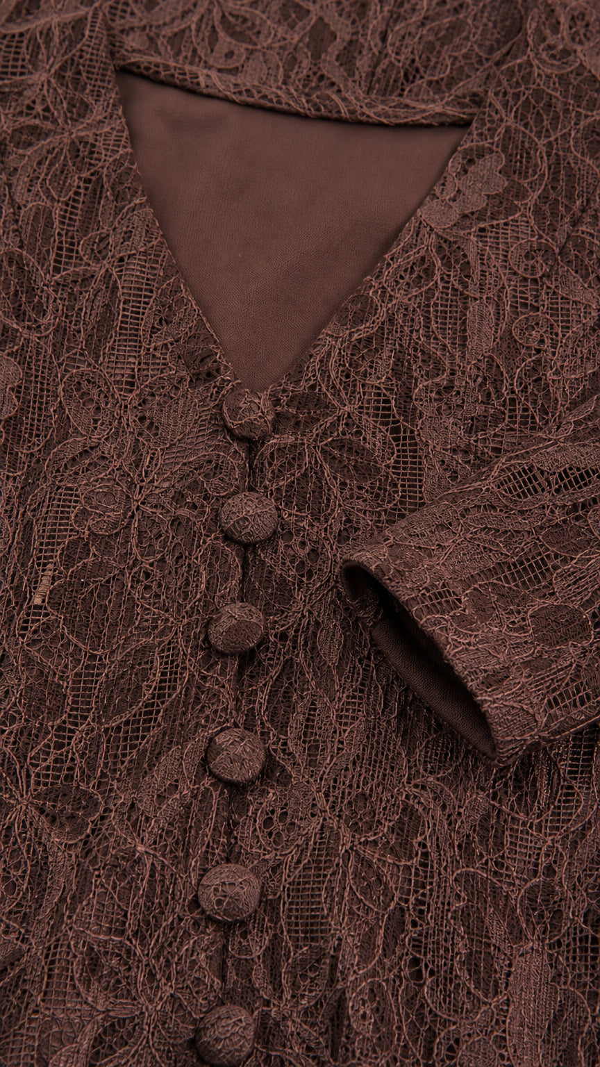 Close-up detail of brown floral lace fabric and covered button placket