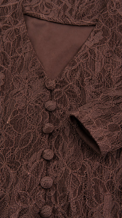 Close-up detail of brown floral lace fabric and covered button placket