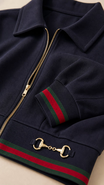 Close-up detail of navy blue jacket collar, gold-tone zipper, and striped ribbed hem with hardware