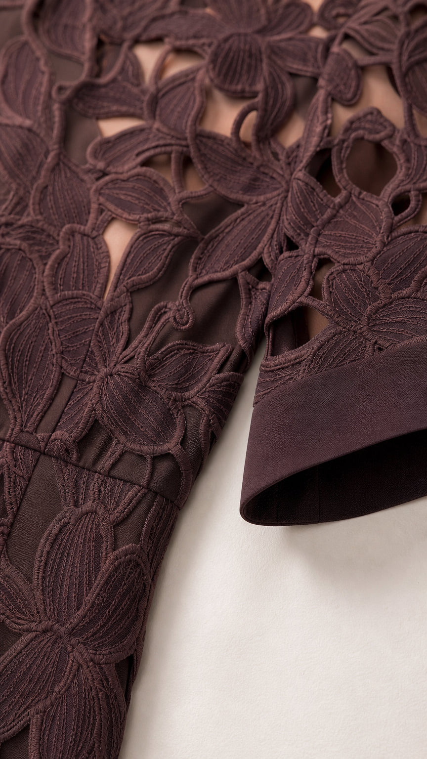 Close-up detail of textured floral lace embroidery and sleeve cuff