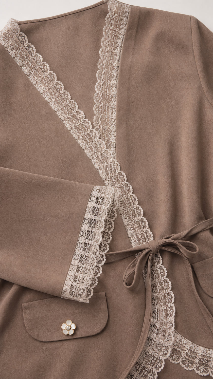 Close-up detail of delicate floral lace trim on collar, cuffs, and pocket button