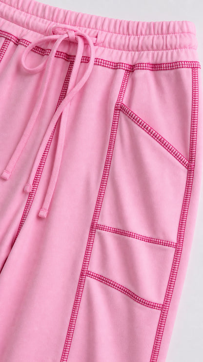 Close-up detail of pastel pink drawstring waist and contrast stitching pockets