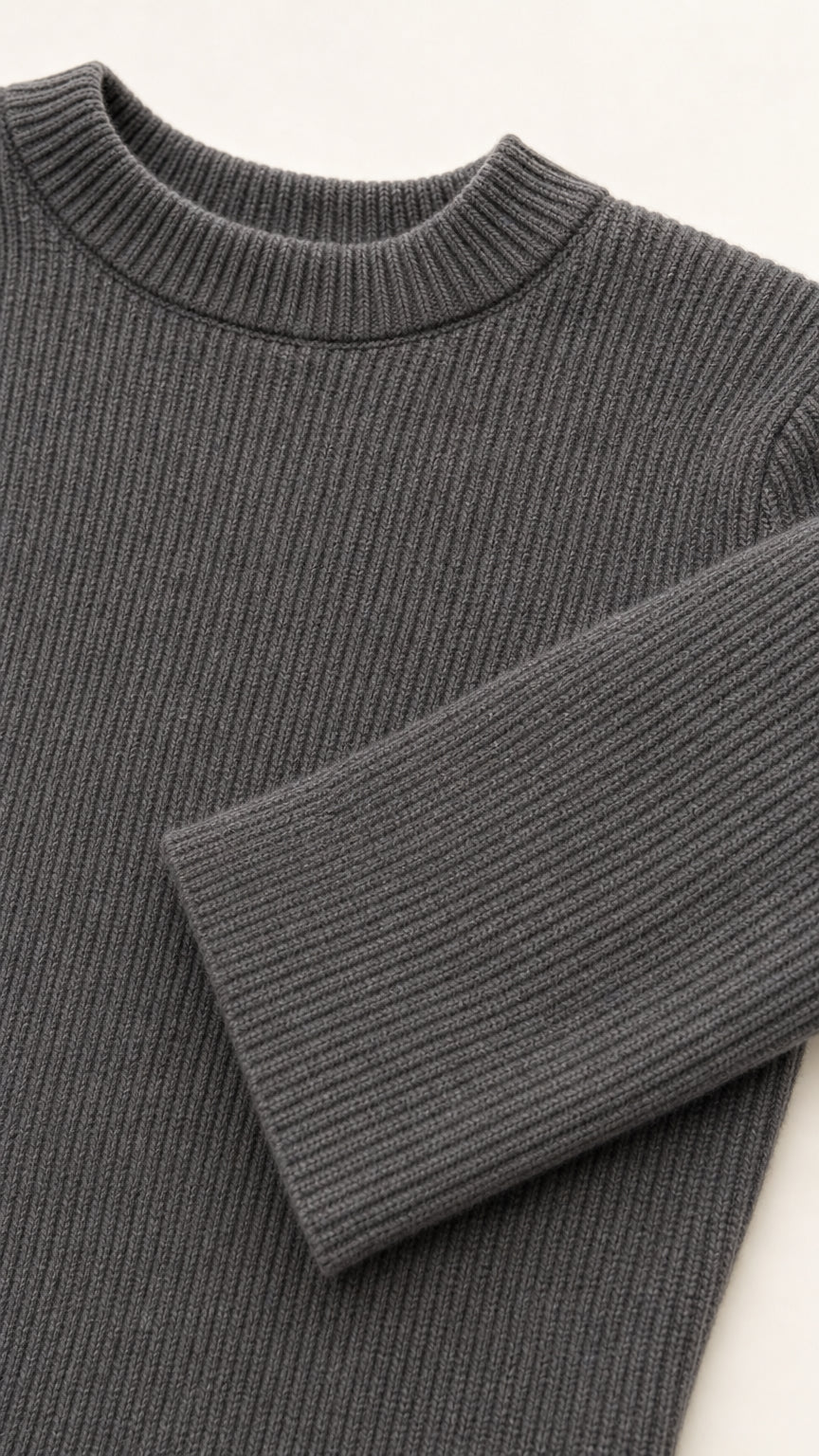 Close-up detail of charcoal grey ribbed knit neckline and sleeve cuff texture