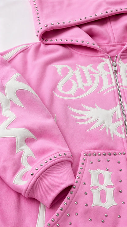 Close-up detail of rhinestone studs and white gothic prints on pink fleece hoodie