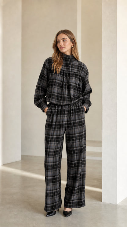 Model wearing charcoal grey plaid mock neck blouse and wide leg trousers set