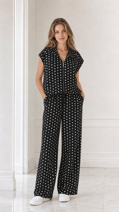 Model wearing black polka dot two-piece matching set with wide leg pants