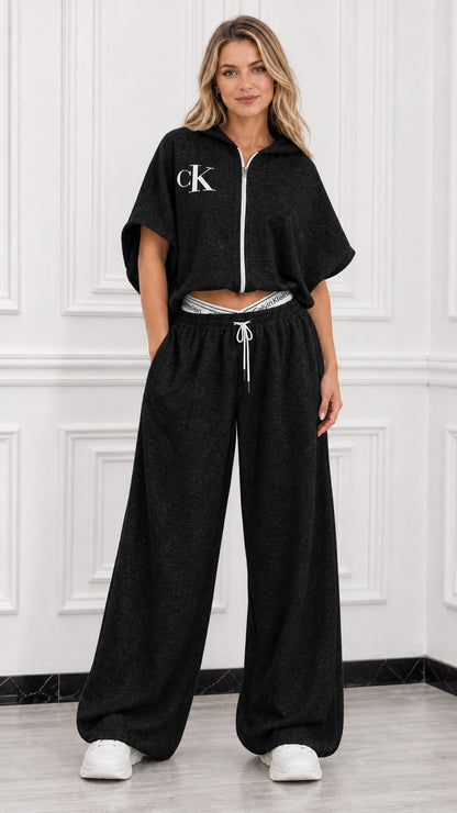 Model wearing black short sleeve cropped zip up hoodie and wide leg sweatpants loungewear set