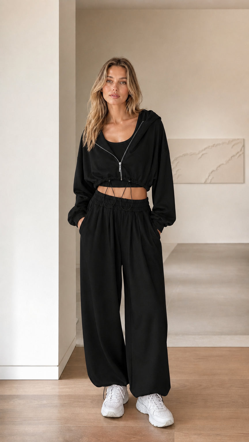 Front view of woman wearing black 3-piece cropped hoodie and sweatpants set