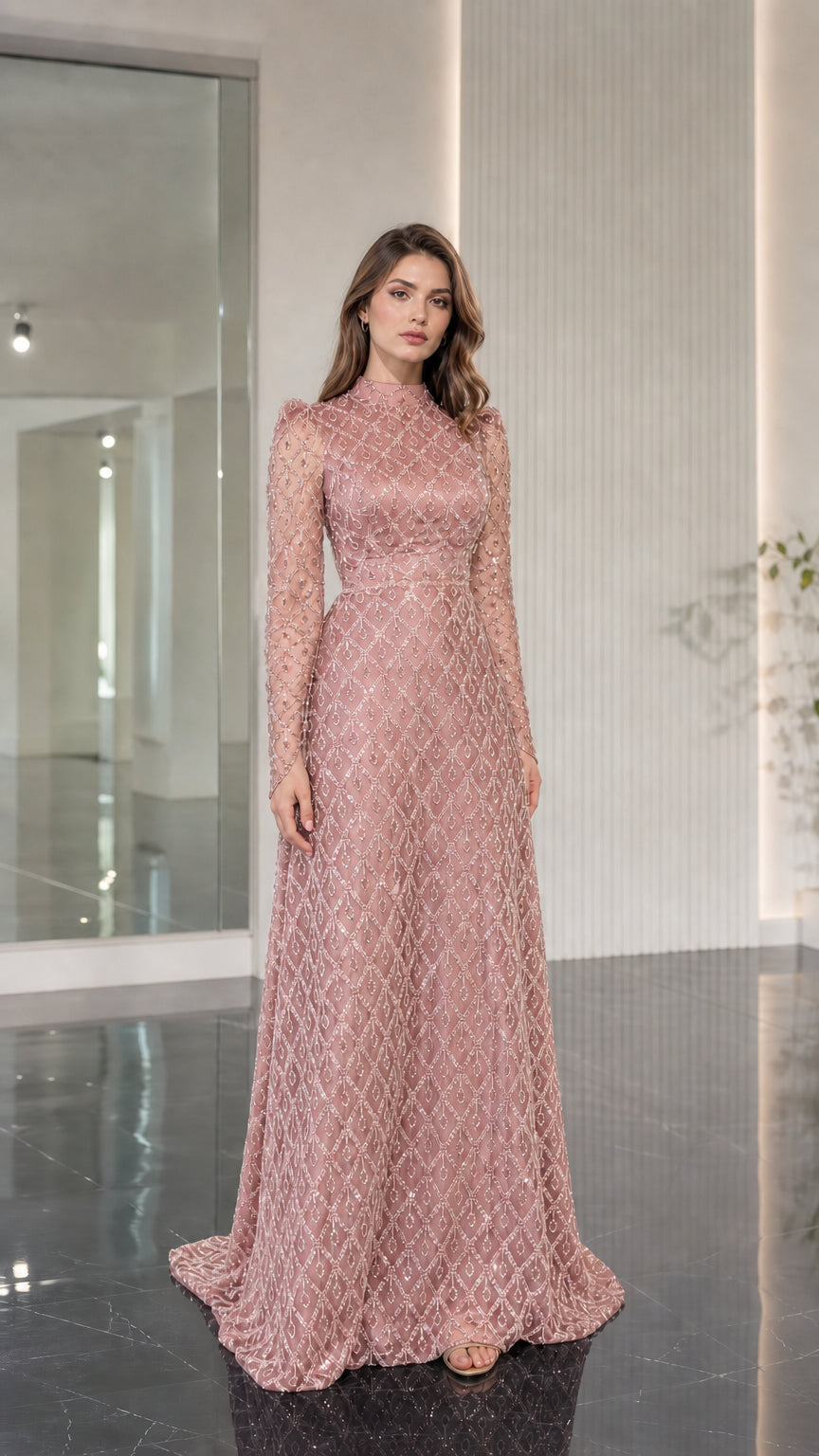 Model wearing blush pink embellished floor length gown with long sleeves