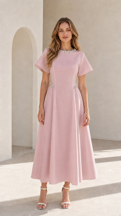 Front view of woman wearing blush pink pearl embellished A-line midi dress
