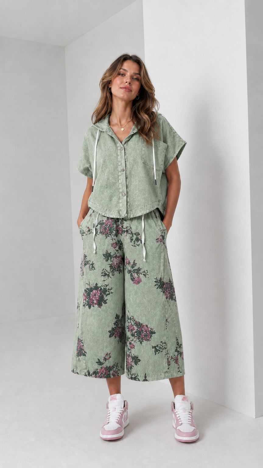 Front view of woman wearing washed sage green hooded shirt and floral wide-leg pants set