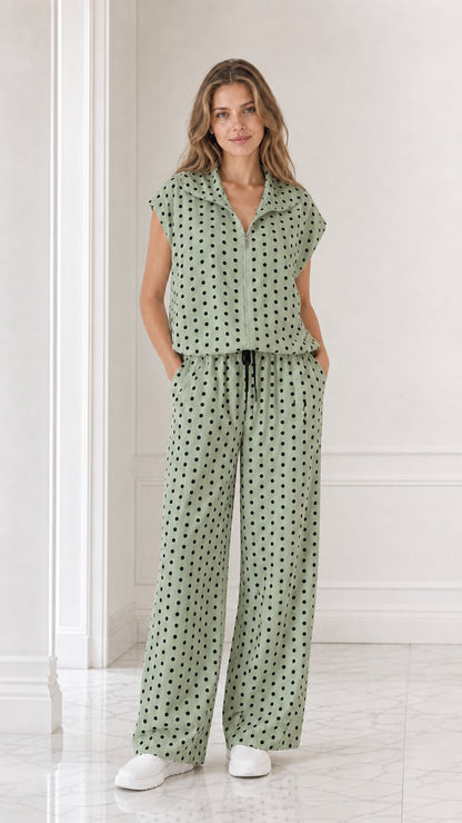 Model wearing sage green polka dot two-piece set with wide leg pants