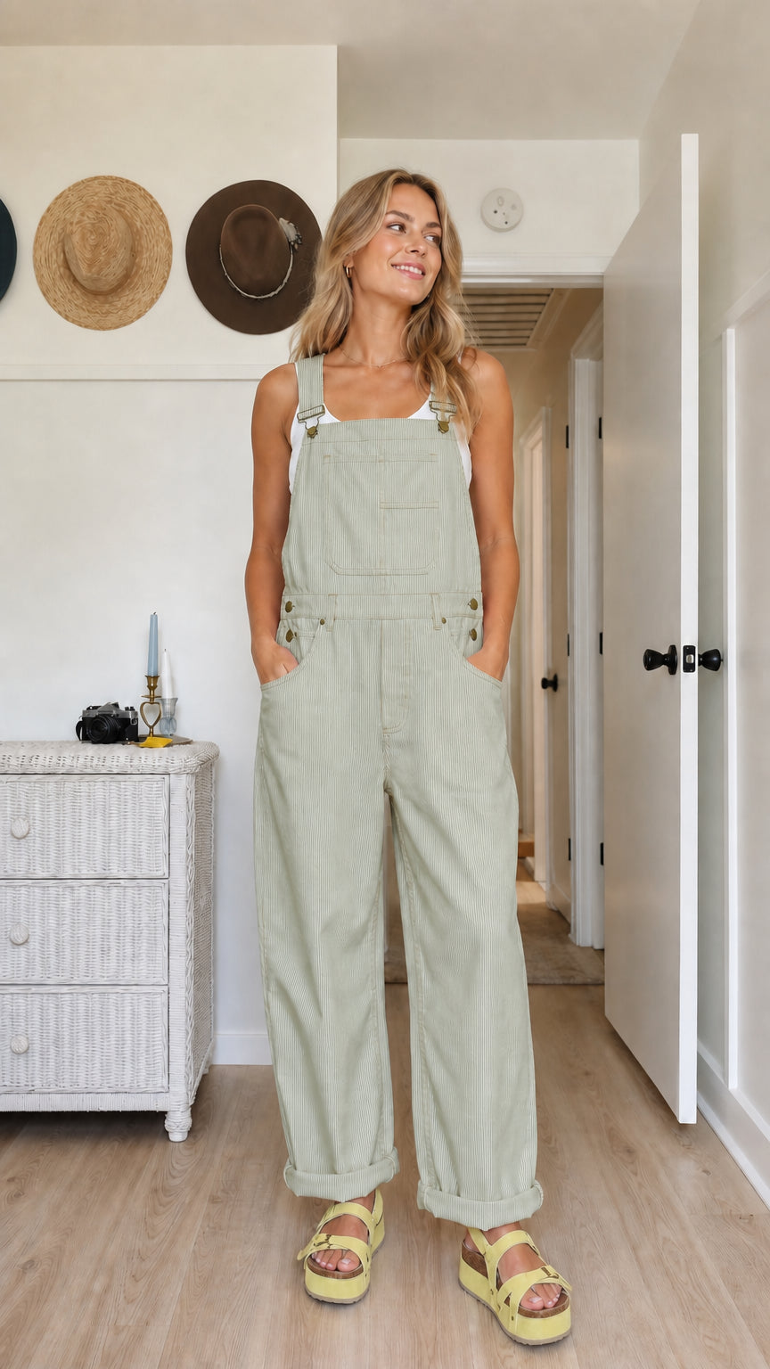 Model wearing sage green wide-leg bib overalls with rolled cuffs and side pockets