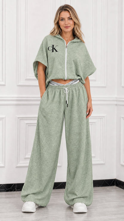 Model wearing sage green short sleeve cropped zip up hoodie and matching wide leg pants