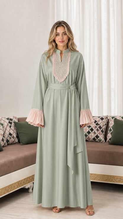 Front view of woman wearing sage green embroidered maxi abaya dress with pleated cuffs