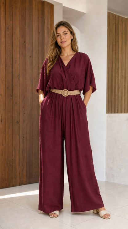 Woman wearing deep burgundy wine wide-leg jumpsuit with belt