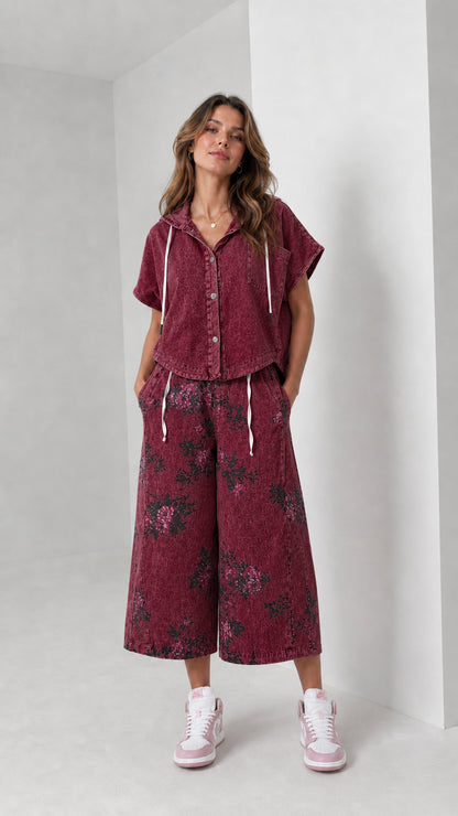 Front view of woman wearing washed burgundy hooded shirt and floral wide-leg pants set