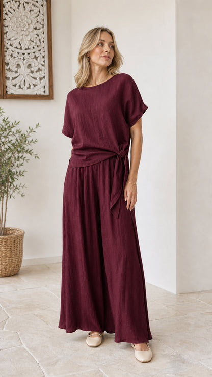 Model wearing burgundy wine red side-tie top and flowy wide-leg pants set