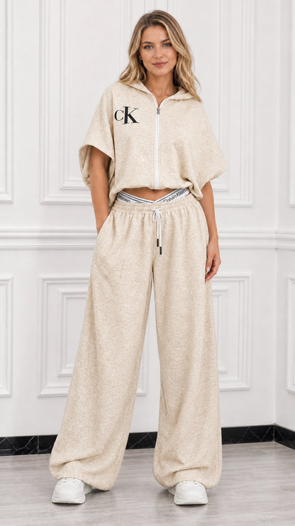 Model wearing beige oatmeal short sleeve cropped hoodie and wide leg sweatpants set